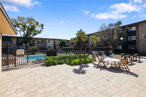 Outdoor view of a swimming pool area within an apartment complex.