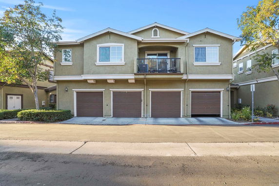 Front view of a two-story house with three garage doors.