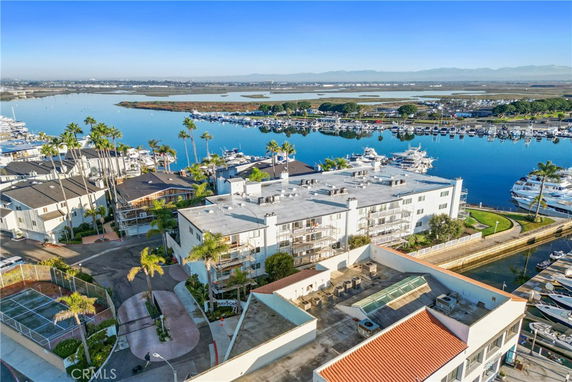 Aerial view of buildings by a marina with boats docked in the water.