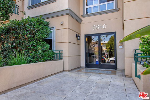 Entrance of a building with glass doors and a visible street number.