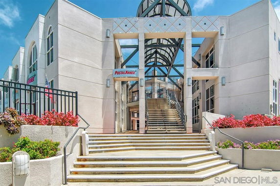 Front view of a modern commercial building with large glass and metal canopy entrance.