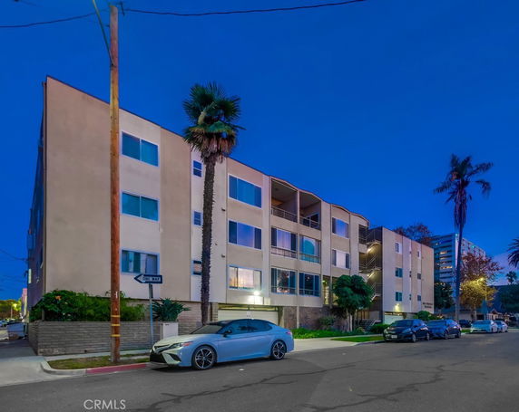 Front view of a multi-story apartment building with balconies.