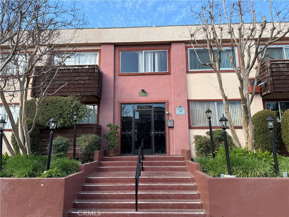 Front view of a two-story building with entrance steps and balconies.
