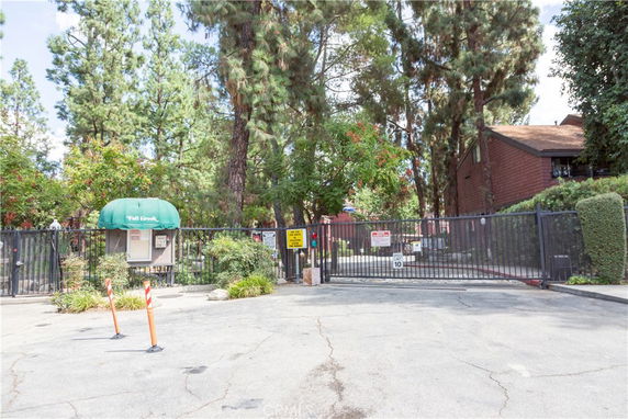 Front view of a gated residential building with trees around.