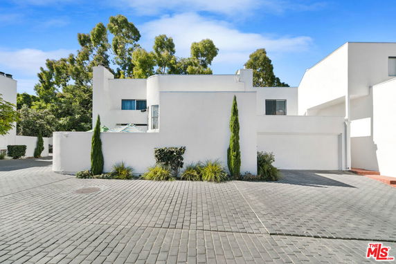 Front view of a modern two-story house with flat roof and white exterior walls.