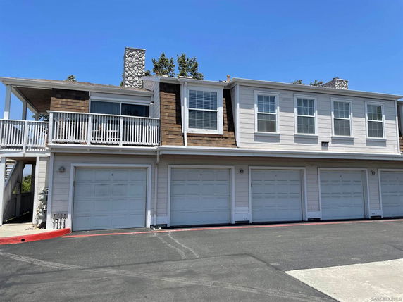 Front view of a two-story building with multiple garages and a balcony.