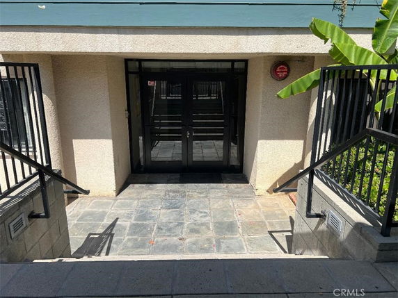 Entrance to a building with stairs leading down to a glass door entryway.
