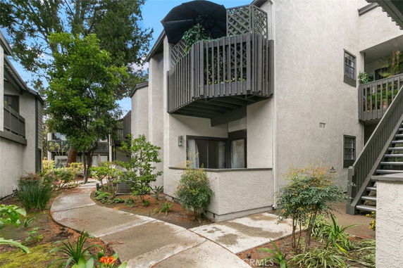 Front view of a multi-story residential building with balconies and exterior staircases.