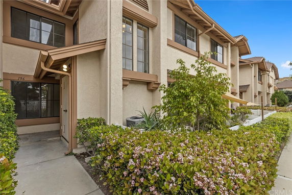 Front view of a multi-story townhouse with beige exterior and brown trim.