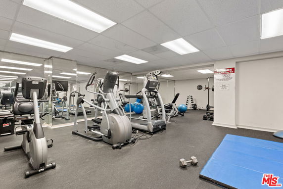 Indoor gym area with exercise equipment and mirrors.