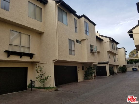 Front view of a multi-story townhouse complex with garages.