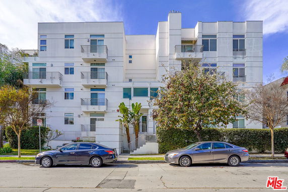 Front view of a multi-story modern apartment building with balconies.