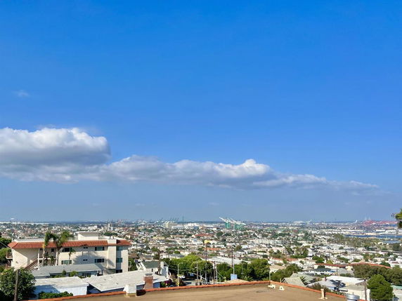 Wide-angle view of a cityscape with buildings and blue sky.