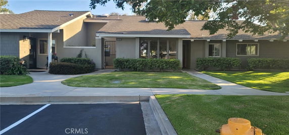 Front view of a single-story house with a well-maintained entrance and green lawn.