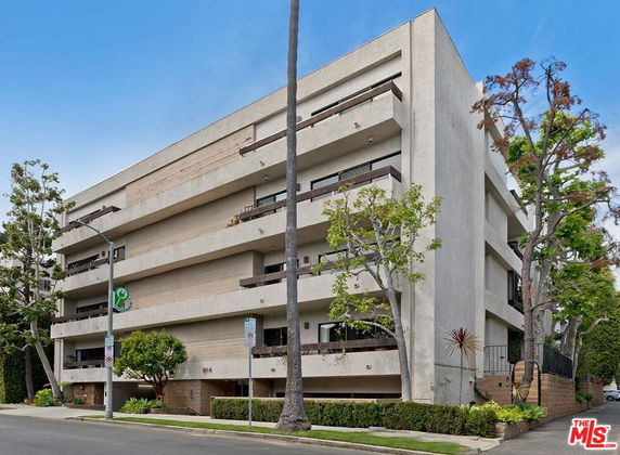 Front view of a multi-story apartment building with balconies.