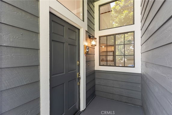 Front view of a house entrance with dark gray door and adjacent windows