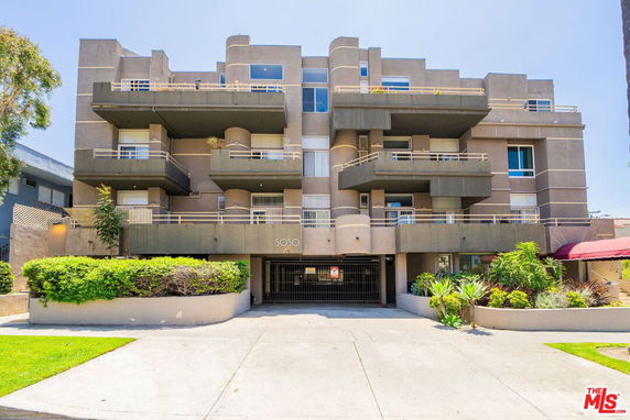 Front view of a multi-story apartment building with balconies.