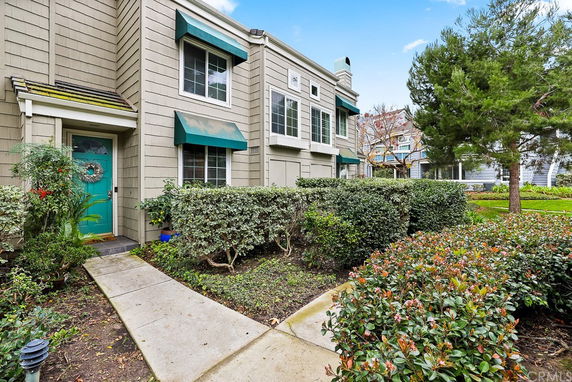 Front view of a two-story house with green awnings and a green front door.