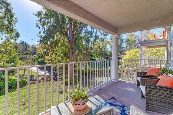 Outdoor patio area of a house with a view of trees and a garden.