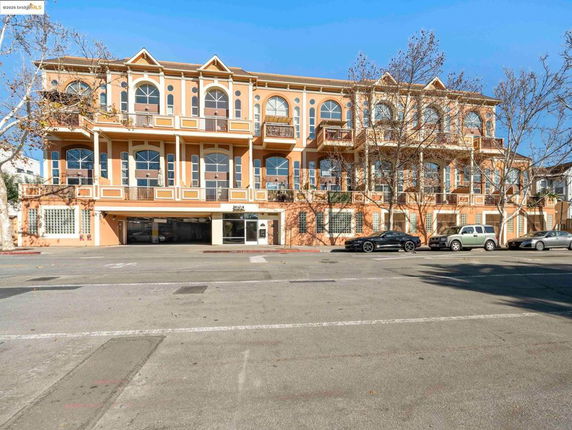 Front view of a multi-story building with large arched windows and balconies.