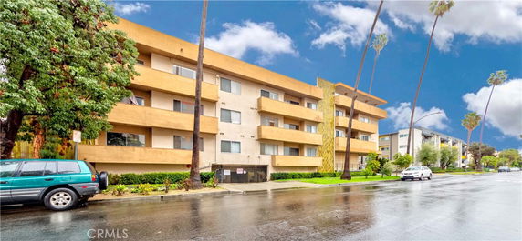 Front view of a multi-story apartment building with balconies.