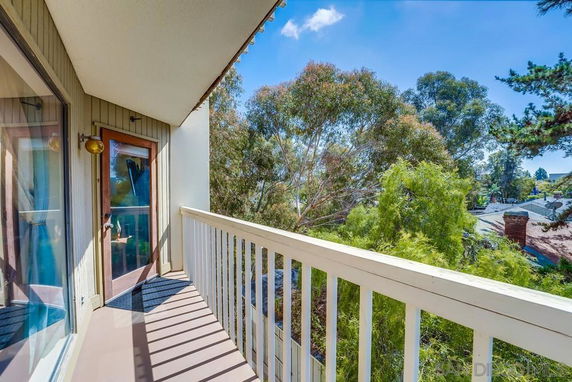 Balcony of a building with view of surrounding trees.
