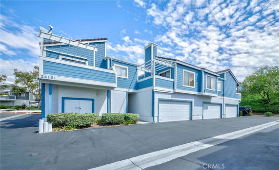 Front view of a two-story house with blue siding and a double garage.
