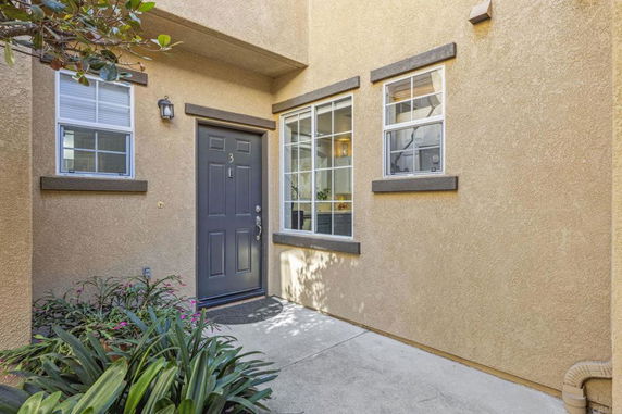 Front view of a house with a black door and two windows.