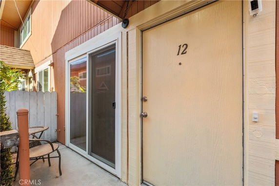 Front entrance of a unit with door number 12 and a sliding glass door.