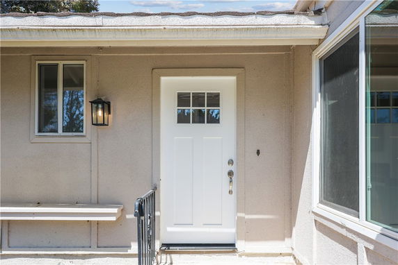 Front view of a house with a white door and adjacent windows