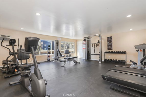 Indoor gym area with exercise equipment including treadmills, elliptical machines, and weight racks.