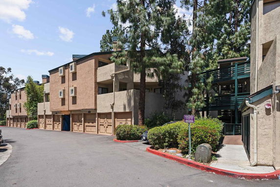Front view of a multi-story building with garages on the ground level.