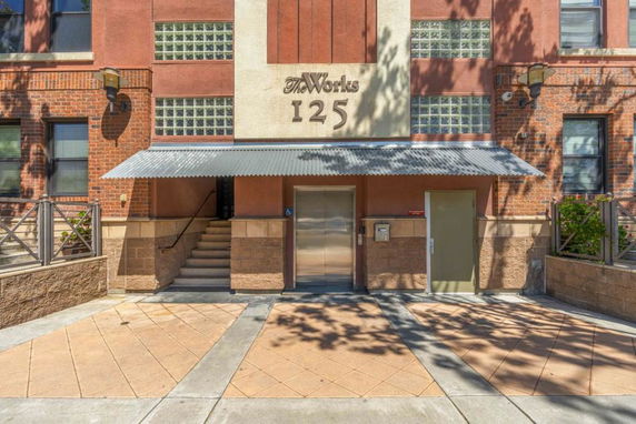 Front view of a building entrance with stairs and a metal awning.