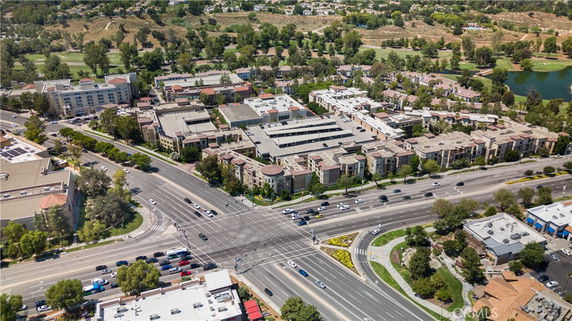 Wide aerial view of urban area with roads and multiple buildings.