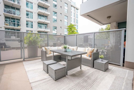 Outdoor patio area with seating and surrounding apartment buildings.