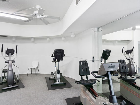 Indoor gym area with exercise equipment and mirrors.