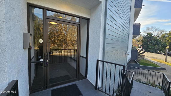 Entrance of a building with a glass door and railing.