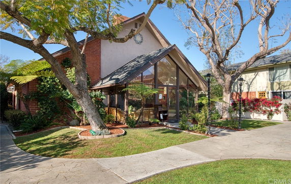 Front view of a house with a large glass facade and a steep gable roof.