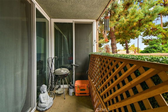 Balcony view with lattice railing and trees visible outside