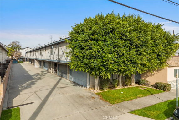 Front view of a row of multiple garage units under a two-story residential structure.