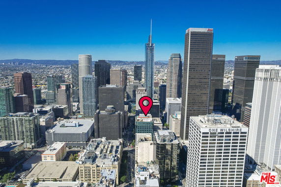 Aerial view of a cityscape with multiple skyscrapers and a clear blue sky.