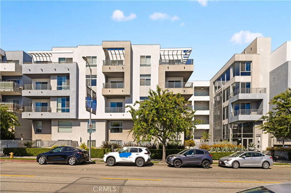 Front view of a modern multi-story apartment building with balconies.