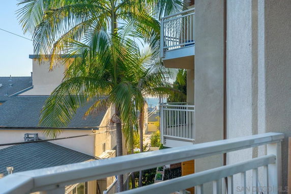 View from a building showing nearby structures and palm trees.