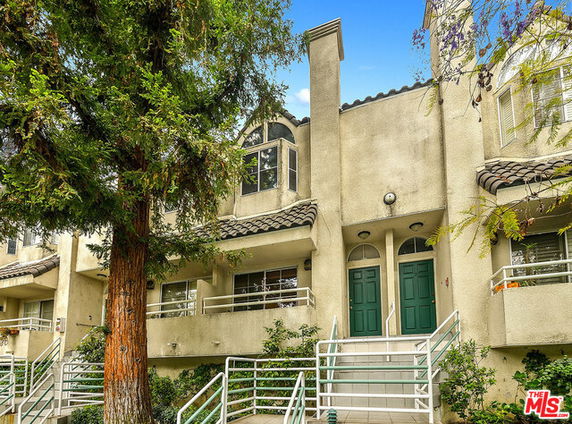 Front view of a multi-story townhouse with dual entry doors and balconies.