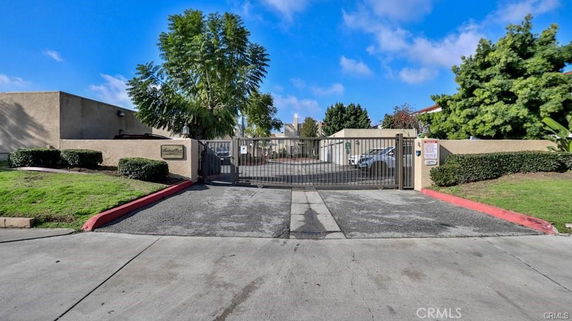 Gated entry to a residential building complex with single-story units.