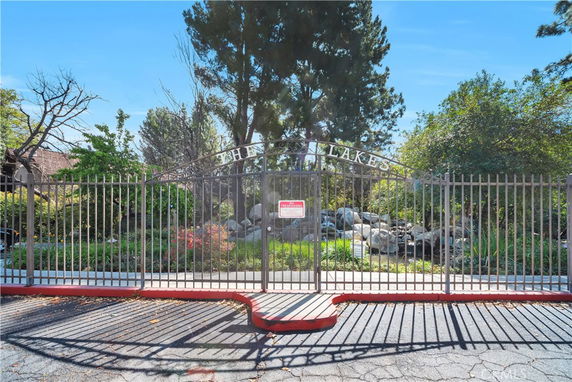 View of a gated entrance with trees and rocks behind.