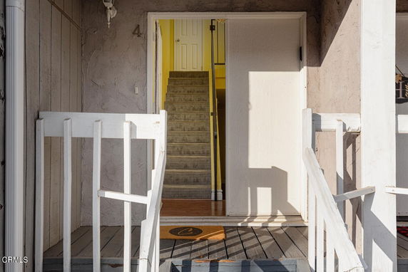 Front view of a building entrance with a staircase leading inside.