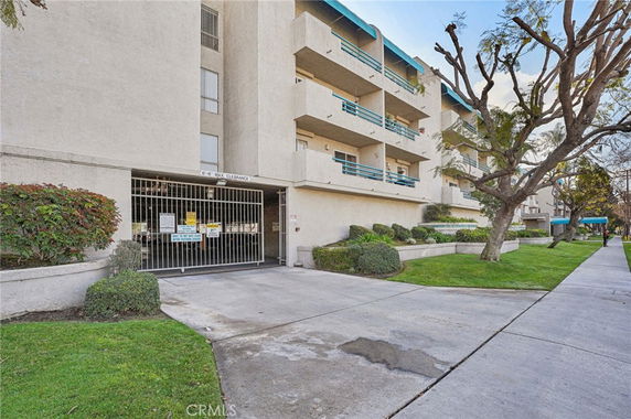 Front view of a multi-story apartment building with balconies.