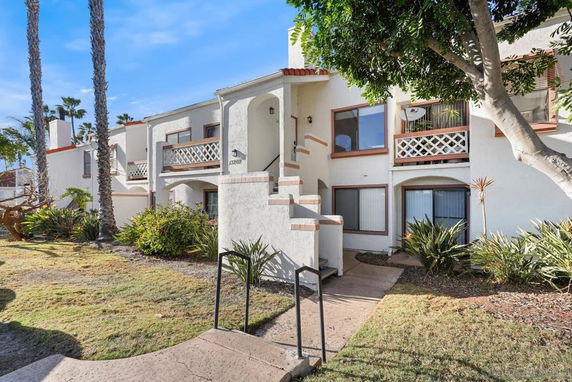Front view of a two-story residential building with white walls and balconies.