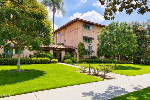 Front view of a multi-story residential building with a well-maintained lawn.